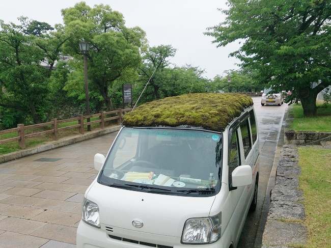 泉原さんが乗るクリーニング集配車の屋根には苔がどっさり。岸和田市は周辺都市で頻繁に目撃され、SNSなどで報告される